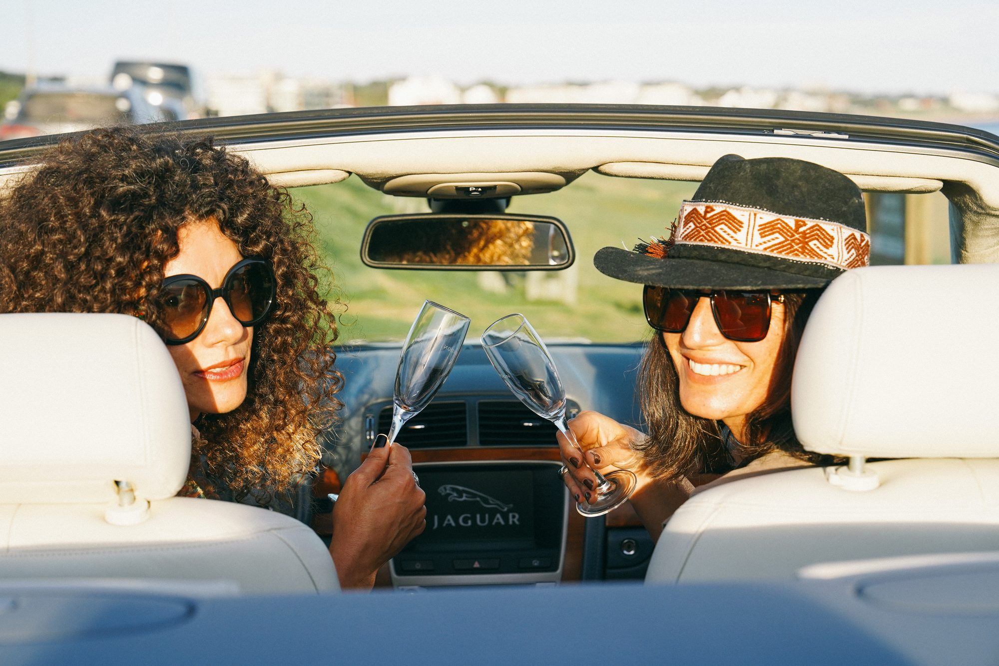 Guests toasting in a Jaguar convertible